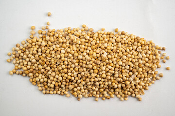 A pile of small, round, coriander seeds
