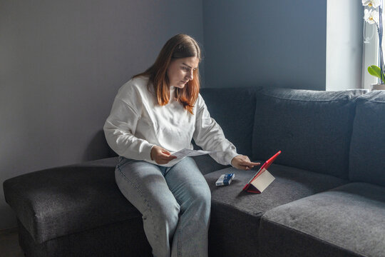 Caucasian woman using rapid antigen test kit for self test COVID-19 epidemic at home. Adult female unpacking a swab for inserts into her nose. COVID-19 coronavirus pandemic protection concept. 