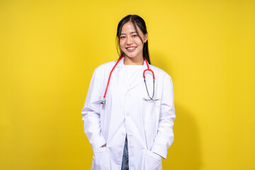 A woman in a white lab coat is smiling and holding a stethoscope