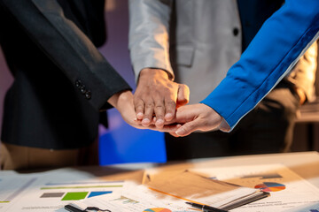 Three people are shaking hands in front of a table with papers on it
