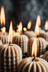 A collection of round white candles glowing with gentle flames, casting light and warmth into the environment. The shapes and uniformity add calm and peaceful vibes.