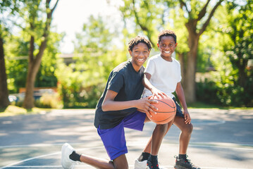 Obraz premium portrait of brother playing with a basketball in park