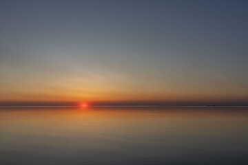 The sun sets on the water. Sunset and calm.