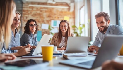 A group of smiling professionals collaborating in a bright office setting with laptops and a warm atmosphere.