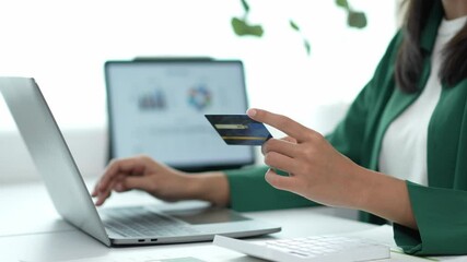 Businesswoman holding credit card typing on laptop - Powered by Adobe