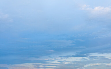Blue sky with fluffy clouds reflecting over the ocean on a sunny day