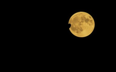 A golden full moon in a dark night sky evokes a sense of mystery and wonder, perfect for projects about astrology, nighttime, or lunar events. 
