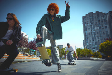 Burst of energy. Dynamic image of stylish men, skaters in motion in public place, park, training,...