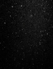 Fototapeta premium Nocturnal Snowfall: Textured White Grain and Dust Against Black