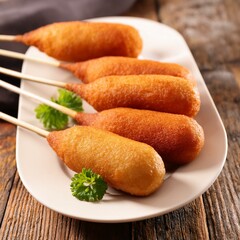 Corndog or corn dog is a american sausage baked in corn flour served with ketchup