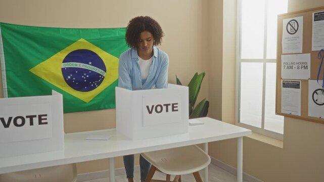 A young woman is casting her vote in an indoor electoral setting with a brazilian flag in the background.