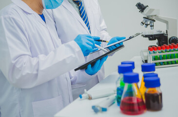 In this chemical experiment, two researchers collaborate to mix reactants, carefully observe...