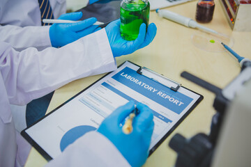 In this chemical experiment, two researchers collaborate to mix reactants, carefully observe...