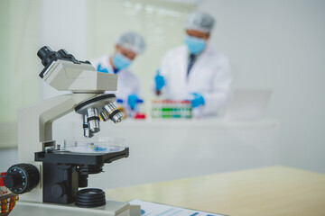 In this chemical experiment, two researchers collaborate to mix reactants, carefully observe changes such as color shifts or gas production, and analyze results, demonstrating principles of chemistry