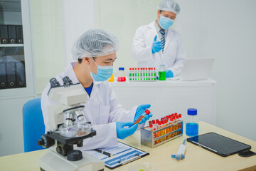 In this chemical experiment, two researchers collaborate to mix reactants, carefully observe...