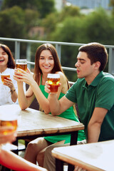 Group portrait of friends sitting at terrace talking, drinking alcohol, celebrating meeting after long years. Festive atmosphere. Concept of Friday mood, celebration, lunch break and Oktoberfest.