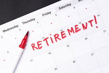 Hand fills in a large wall calendar, counting down the days until retirement, writing 'Retirement'. Concept of early retirement, the Financial Independence, Retire Early movement (FIRE)