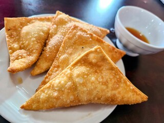 Golden Brown Fried Wontons with Dipping Sauce at Eye-Level Perspective