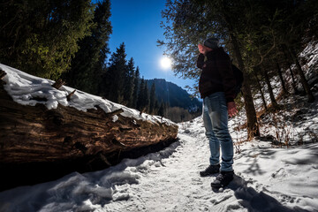 Hiker man walk trail along the winter Bear Gorge in the Almaty region of Kazakhstan. Amazing landscapes of Central Asia.