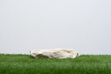 Stone podium table top with green grass isolate on white background empty space.cosmetic beauty product present placement pedestal display,natural minimal stage concept.