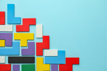 Obraz premium Colorful wooden puzzle pieces on light blue background, top view. Space for text