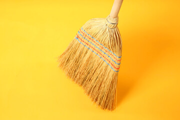 One corn straw broom on yellow background