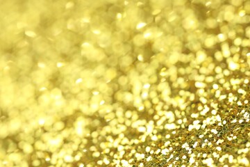 Beautiful shiny golden glitter as background, closeup