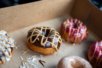 Glazed donuts in a box with different toppings