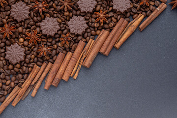 Food background. Coffee beans, cinnamon sticks, anise stars and chocolate candies top view. Copy space.