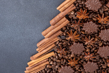 Food background. Coffee beans, cinnamon sticks, anise stars and chocolate candies top view. Copy space.