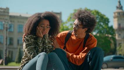 African American ethnic students friends sad stressed woman girl female suffer bad exam result education trouble man male guy calm support help outside city friendship university college high school