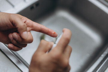 Man cut finger while cooking in kitchen, closeup