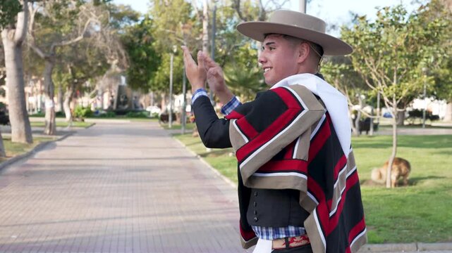 pareja de huasos chilenos bailando cueca en la plaza de la ciudad, concepto celebraci&oacute;n fiestas patrias 