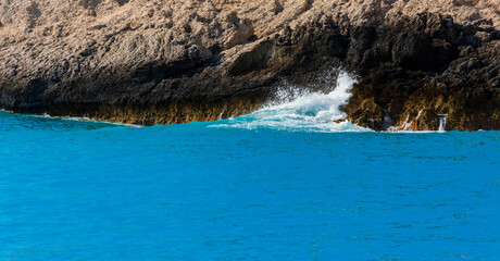 Landscape with blue sea and brown rock.