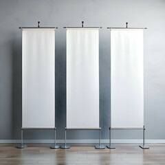 Three blank roll up banners standing in a room ready for your message.