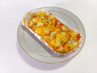 Cheesy bread topped with shredded cheese, chili sauce, and mayonnaise, served on a white round plate against a clean white background, offering a delicious blend of flavors