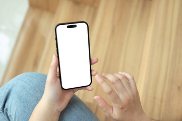 Young woman sitting with leg crossed holding a smartphone with a blank white screen