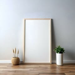 A blank canvas for your creativity!  This minimalist mockup features a large. wood framed picture on a neutral backdrop with a potted plant and decorative reeds.