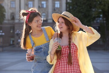 Happy teenage friends posing on city street