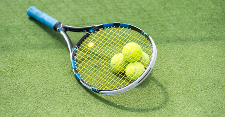 Tennis balls on a racket on the court ground