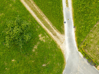 Aerial view of path through rural landscape in Switzerland. Road between fields.