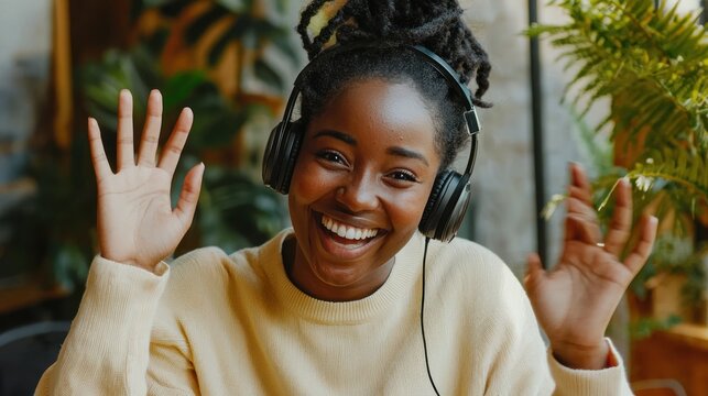 A person making a video call, smiling and waving as they introduce themselves to a new group or audience