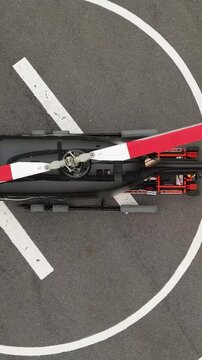 helicopter parked on helipad with remote controlled pushback cart driving underneath black modern 
