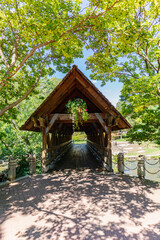 Wooden covered bridge in summer over a river