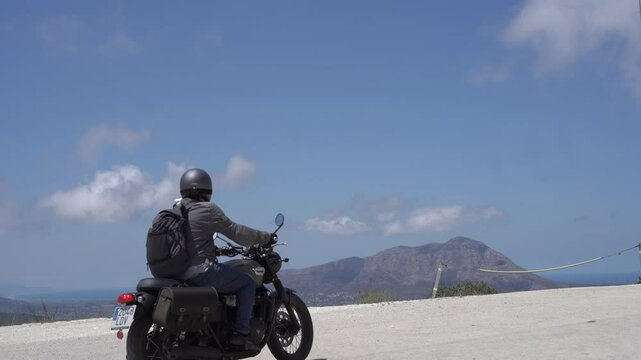 Hombre en moto cl&aacute;sica de viaje