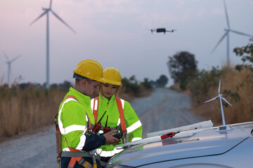 Engineer remote control drone survey and inspect of hight angle win turbines field, Industry nature environment concept.