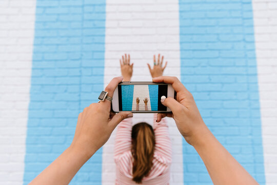 Woman takes photo on a cell phone of a woman