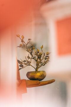 A decorative tree in the hand of the statue.