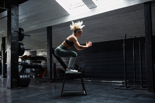 Fit female practicing box jump in the gym