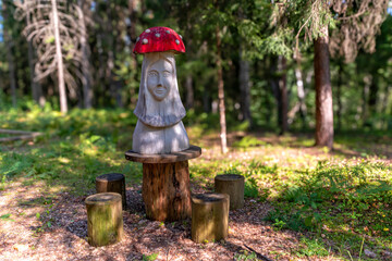 Fototapeta premium A charming wooden sculpture sits surrounded by nature in a peaceful forest setting.